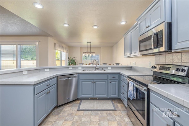 6229 S Snowdrop Way, Boise, ID 83716 - kitchen featuring stainless steel appliances, a sink, stone finish flooring, a peninsula, and recessed lighting