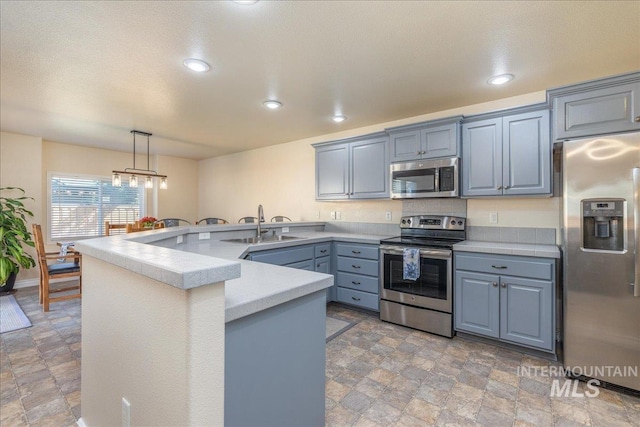 6229 S Snowdrop Way, Boise, ID 83716 - kitchen featuring stainless steel appliances, stone finish floors, light countertops, a sink, and a peninsula