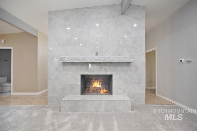 room details featuring beam ceiling and a tiled fireplace