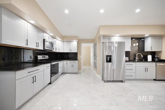 kitchen with stainless steel appliances, white cabinetry, tasteful backsplash, and sink