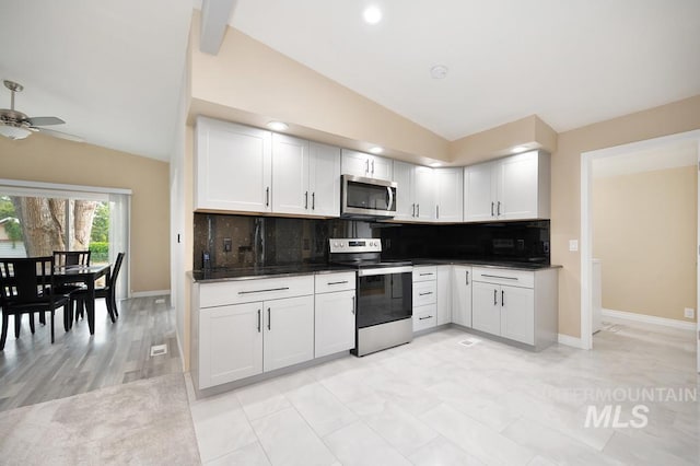 kitchen with ceiling fan, white cabinetry, stainless steel appliances, tasteful backsplash, and vaulted ceiling