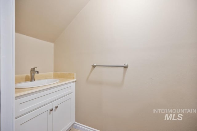 bathroom featuring lofted ceiling and vanity