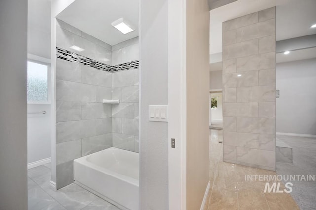 bathroom featuring tiled shower / bath and a healthy amount of sunlight