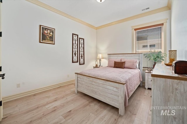 bedroom with visible vents, ornamental molding, light wood-style flooring, and baseboards