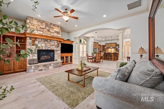 living room featuring ornamental molding, decorative columns, and ceiling fan