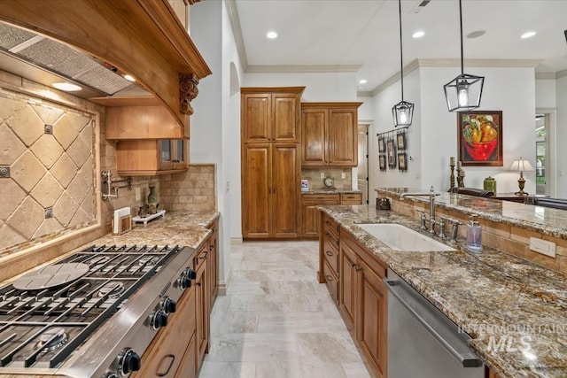 kitchen with a sink, appliances with stainless steel finishes, brown cabinets, and light stone counters