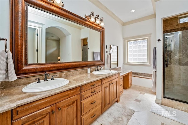 bathroom with double vanity, a sink, a stall shower, and a wealth of natural light
