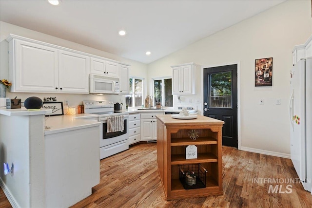 kitchen featuring vaulted ceiling, white cabinets, light hardwood / wood-style flooring, and white appliances