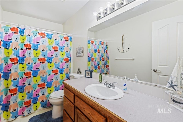 full bath featuring vanity, a shower with curtain, and toilet