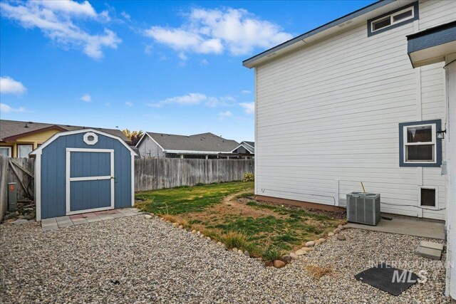 view of yard featuring cooling unit, an outbuilding, a shed, and a fenced backyard