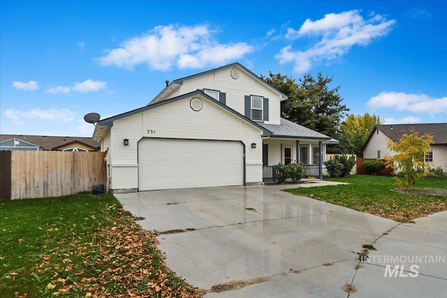 traditional home featuring an attached garage, fence, driveway, and a front yard