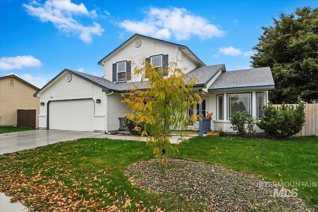 view of front of home featuring driveway, roof with shingles, a front yard, fence, and an attached garage