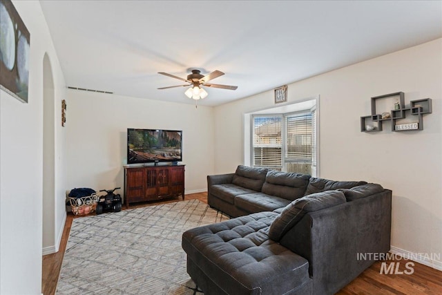 living room with light hardwood / wood-style flooring and ceiling fan