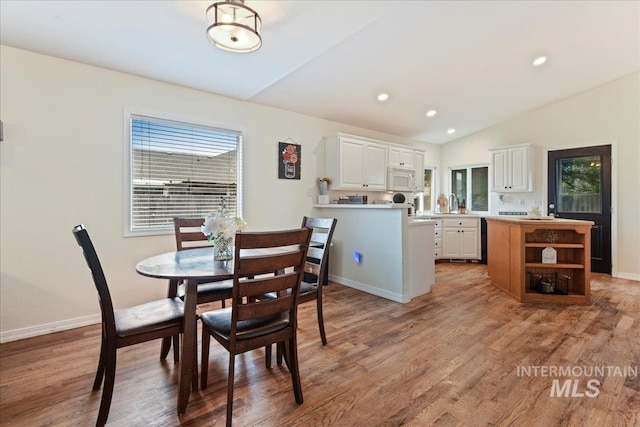 dining room with baseboards, recessed lighting, light wood-style flooring, and lofted ceiling