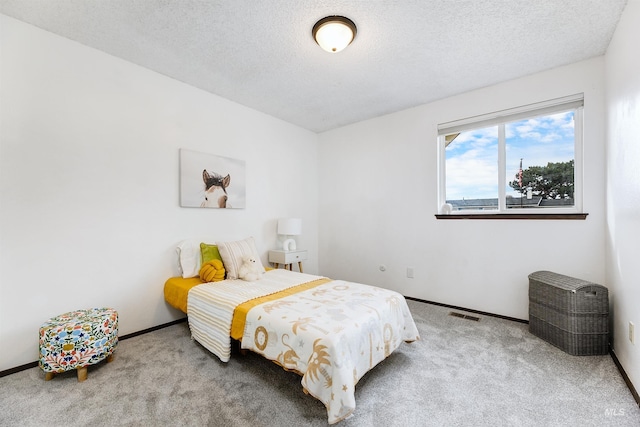 bedroom with baseboards, visible vents, a textured ceiling, and carpet