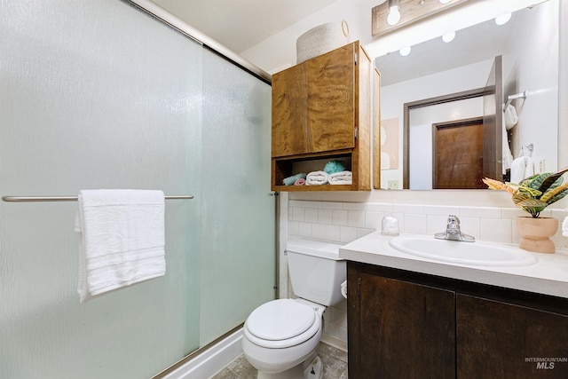 bathroom with vanity, a shower stall, toilet, and tasteful backsplash