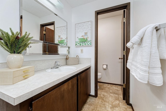 bathroom featuring tile patterned flooring, toilet, vanity, and baseboards