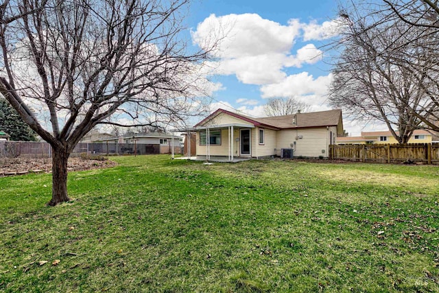 back of property with a lawn, a patio, central AC, and a fenced backyard