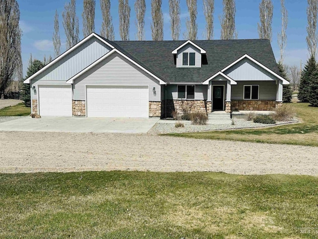 382 N 1020 E, Declo, ID 83323 - craftsman-style house featuring an attached garage, a shingled roof, concrete driveway, stone siding, and a front lawn