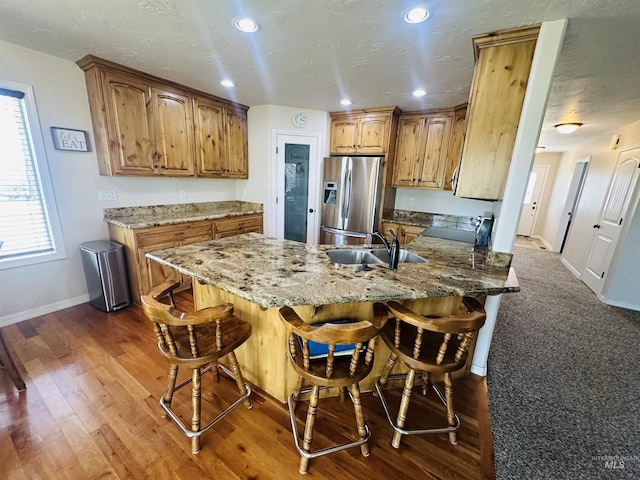 382 N 1020 E, Declo, ID 83323 - kitchen featuring a peninsula, a sink, stainless steel fridge with ice dispenser, baseboards, and light stone counters