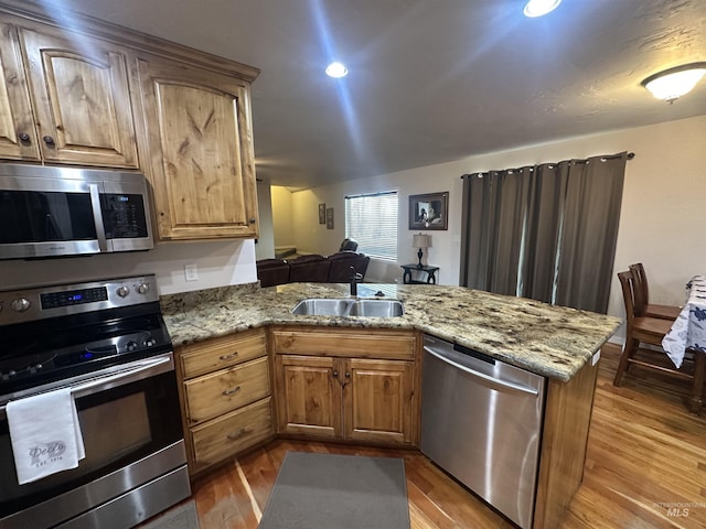 382 N 1020 E, Declo, ID 83323 - kitchen featuring a sink, a peninsula, stainless steel appliances, and light stone countertops