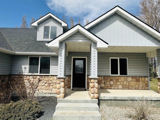 382 N 1020 E, Declo, ID 83323 - view of front facade with stone siding, roof with shingles, covered porch, and board and batten siding