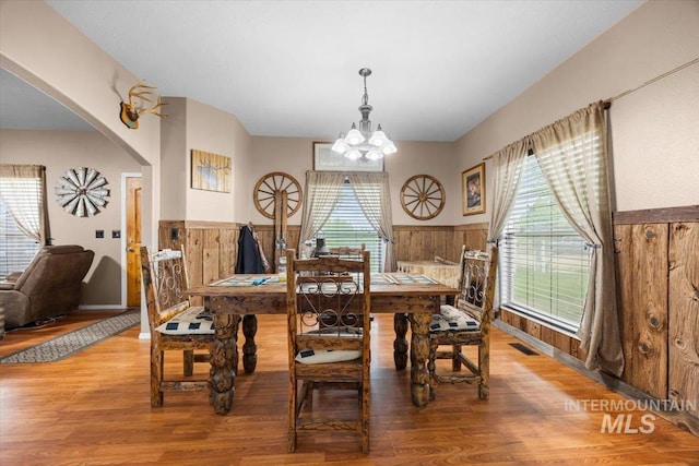 3856 Wood Way, New Plymouth, ID 83655 - dining space with a notable chandelier, wainscoting, light wood finished floors, arched walkways, and visible vents