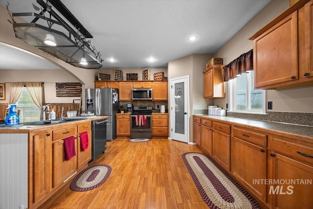 3856 Wood Way, New Plymouth, ID 83655 - kitchen with a sink, light wood-style flooring, appliances with stainless steel finishes, and brown cabinets
