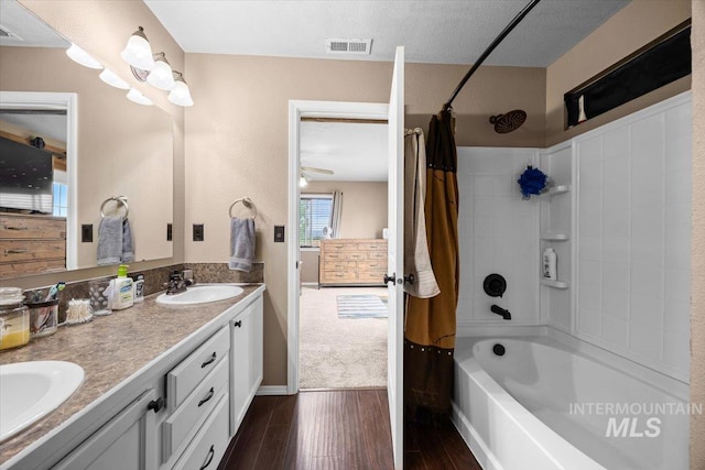 3856 Wood Way, New Plymouth, ID 83655 - bathroom featuring double vanity, visible vents, wood finished floors, a sink, and shower / bathtub combination with curtain