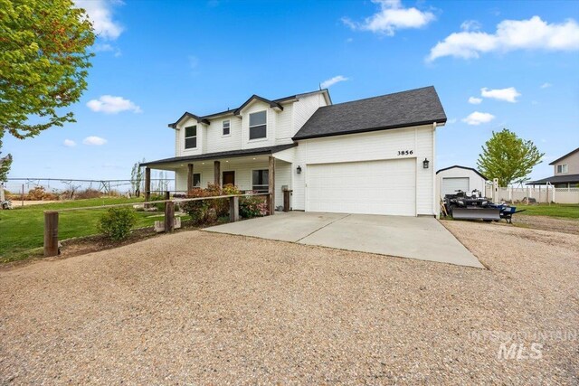 3856 Wood Way, New Plymouth, ID 83655 - view of front of house with fence, dirt driveway, an attached garage, and covered porch