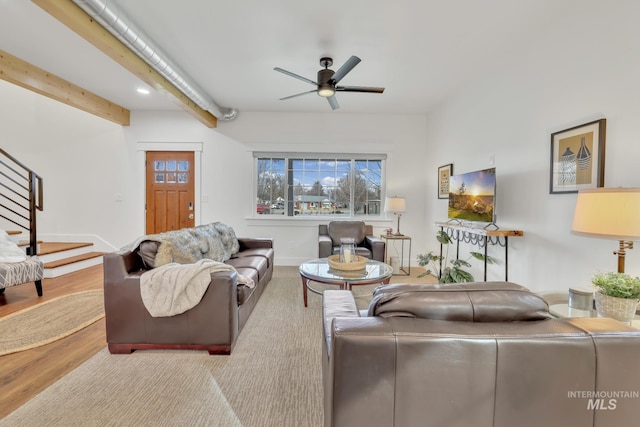 living room featuring ceiling fan, light wood-type flooring, and beam ceiling