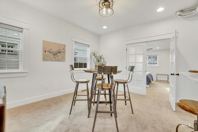 carpeted dining space featuring french doors