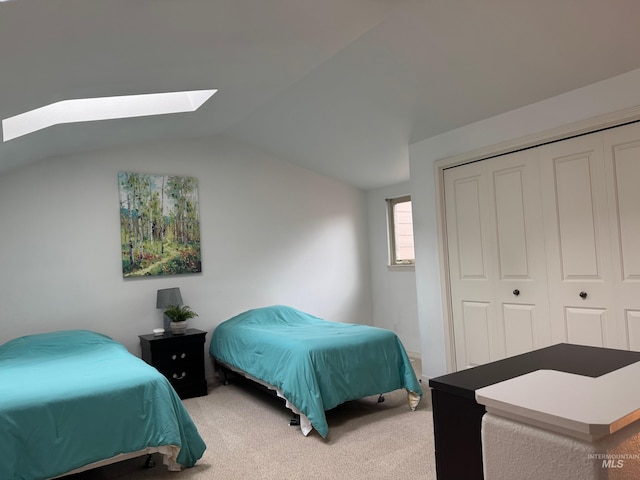 bedroom featuring a closet, lofted ceiling with skylight, and carpet flooring