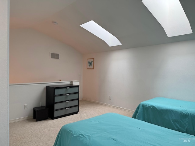 bedroom with visible vents, vaulted ceiling with skylight, carpet flooring, and baseboards