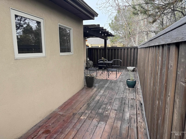 wooden terrace featuring outdoor dining area and fence