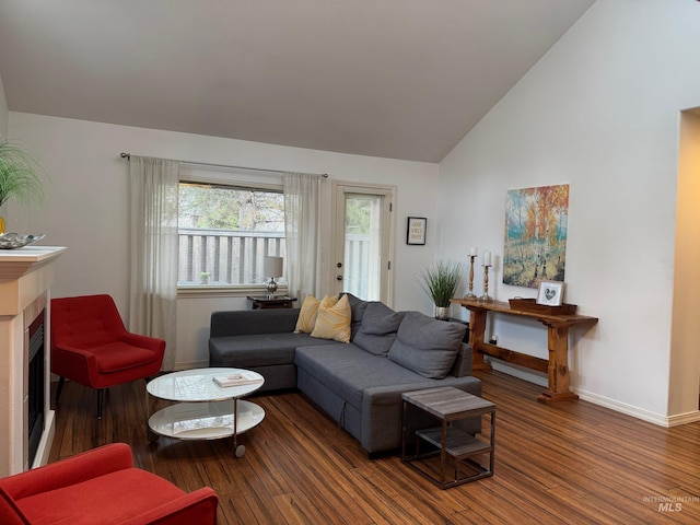 living room featuring a fireplace, baseboards, lofted ceiling, and wood finished floors