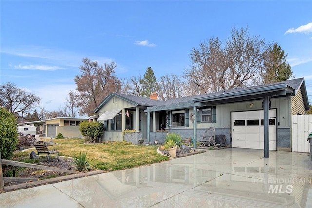 single story home with a front yard, driveway, an attached garage, brick siding, and board and batten siding