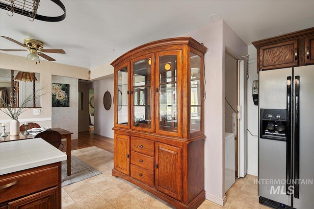 kitchen with refrigerator with ice dispenser, tile countertops, and a ceiling fan