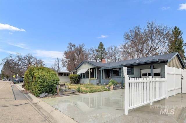 ranch-style house featuring a garage, a chimney, and fence