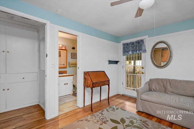 sitting room with ceiling fan and wood finished floors