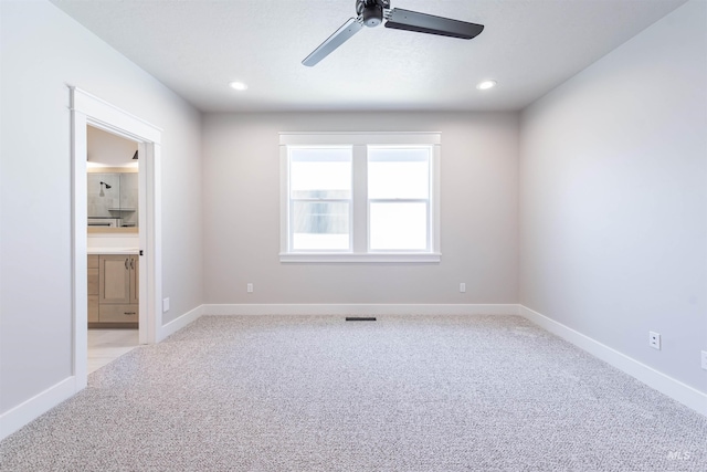 spare room with baseboards, visible vents, and light colored carpet