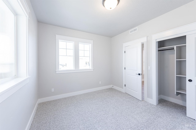 unfurnished bedroom featuring carpet floors, visible vents, and baseboards