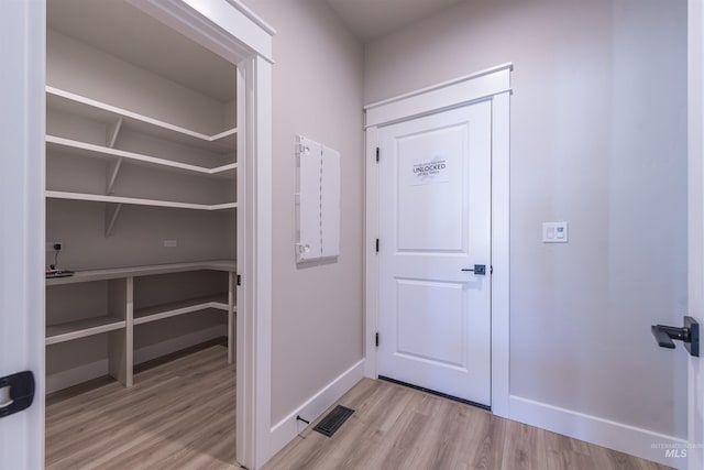 interior space featuring light wood-style floors, visible vents, and baseboards