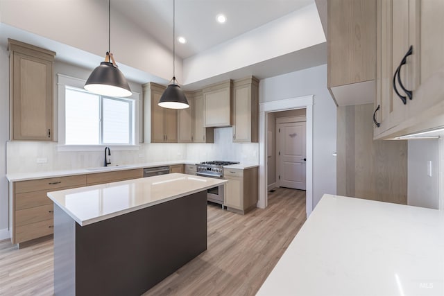 kitchen with a kitchen island, hanging light fixtures, stainless steel appliances, light countertops, and a sink