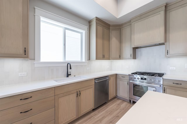 kitchen featuring decorative backsplash, appliances with stainless steel finishes, light countertops, and a sink