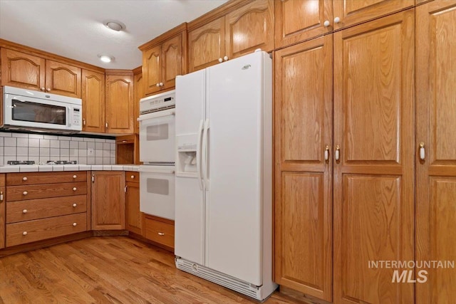 10809 W Cruser, Boise, ID 83709 - kitchen featuring white appliances, brown cabinets, and light wood-style floors