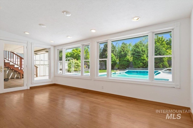 10809 W Cruser, Boise, ID 83709 - unfurnished sunroom with wood finished floors, healthy amount of natural light, baseboards, a textured ceiling, and recessed lighting