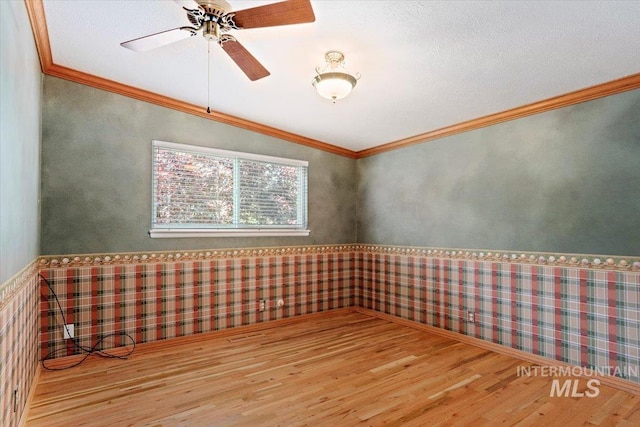 10809 W Cruser, Boise, ID 83709 - empty room with wood finished floors, wainscoting, a ceiling fan, and ornamental molding