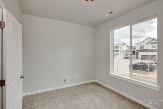 empty room with light colored carpet and plenty of natural light