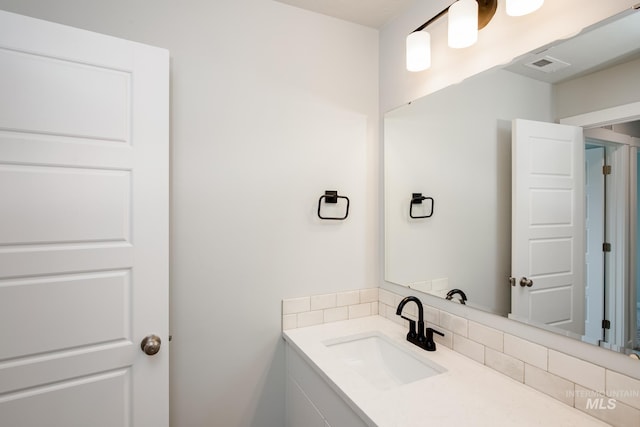 bathroom with vanity and tasteful backsplash